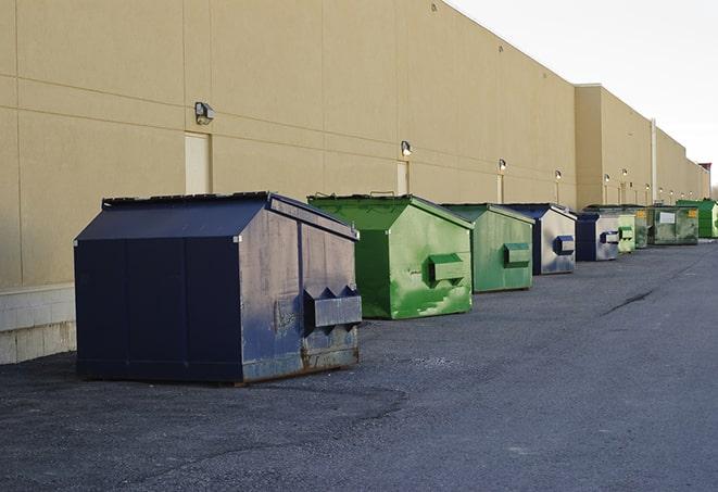 a waste management truck unloading into a construction dumpster in Anderson